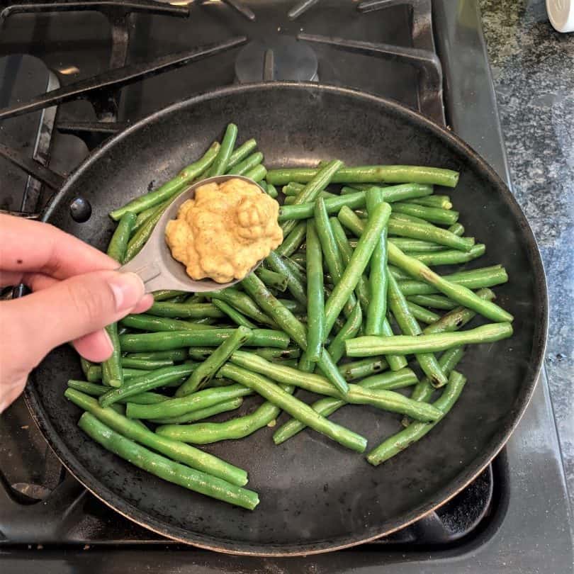 Cooking Mustard Green Beans on the stovetop.