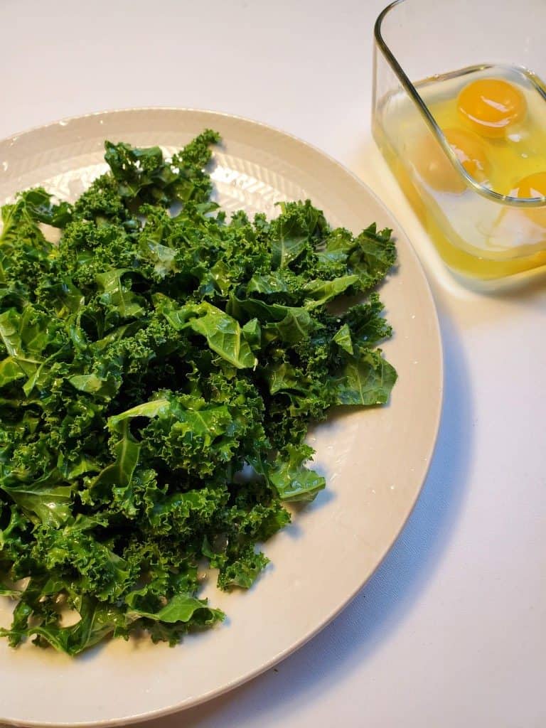 kale on a plate with eggs in a bowl
