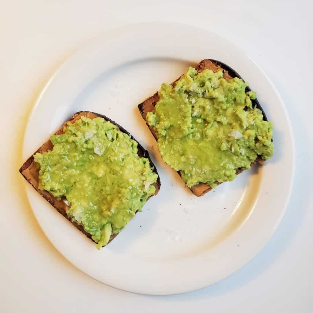 Peanut Butter Avocado Toast on Plate with honey and salt