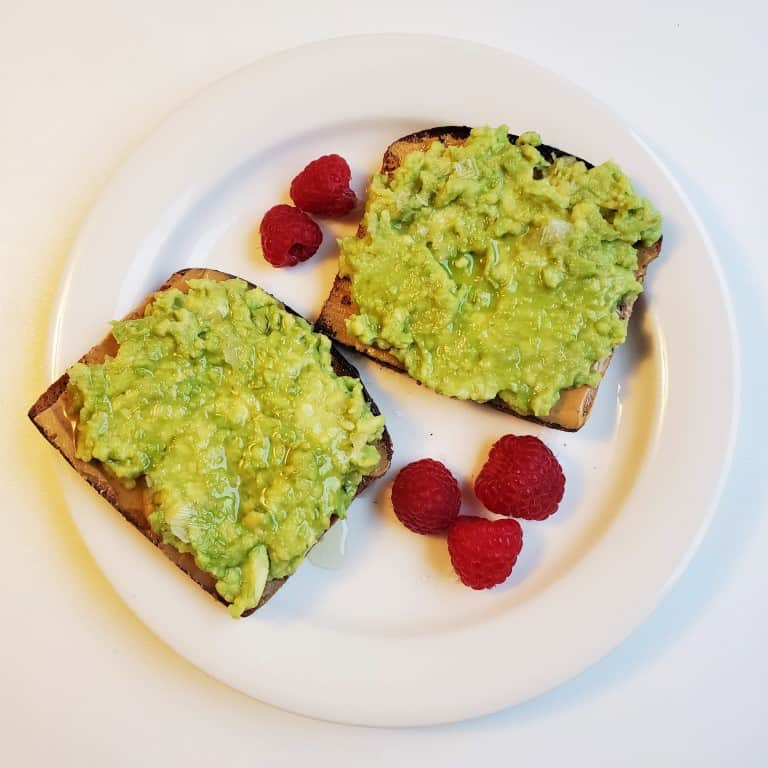 Peanut Butter Avocado Toast on Plate with Raspberries