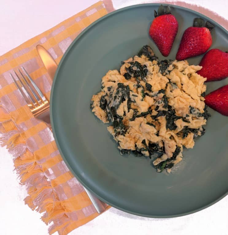 Plate of pregnancy breakfast: kale egg scramble with fruit.
