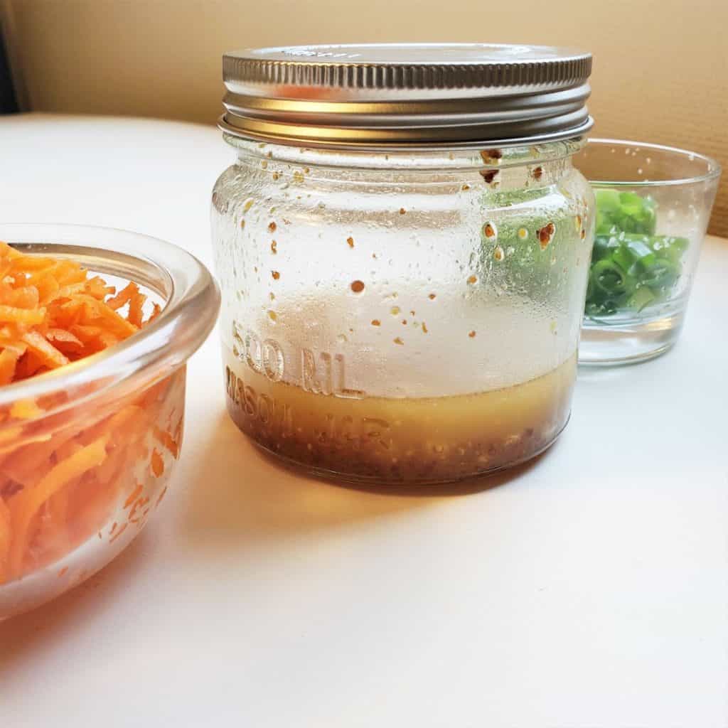 Mixed apple cider vinaigrette dressing in a mason jar for kale crunch salad recipe