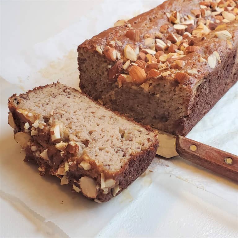 A thick slice of almond flour banana cake on waxed paper.