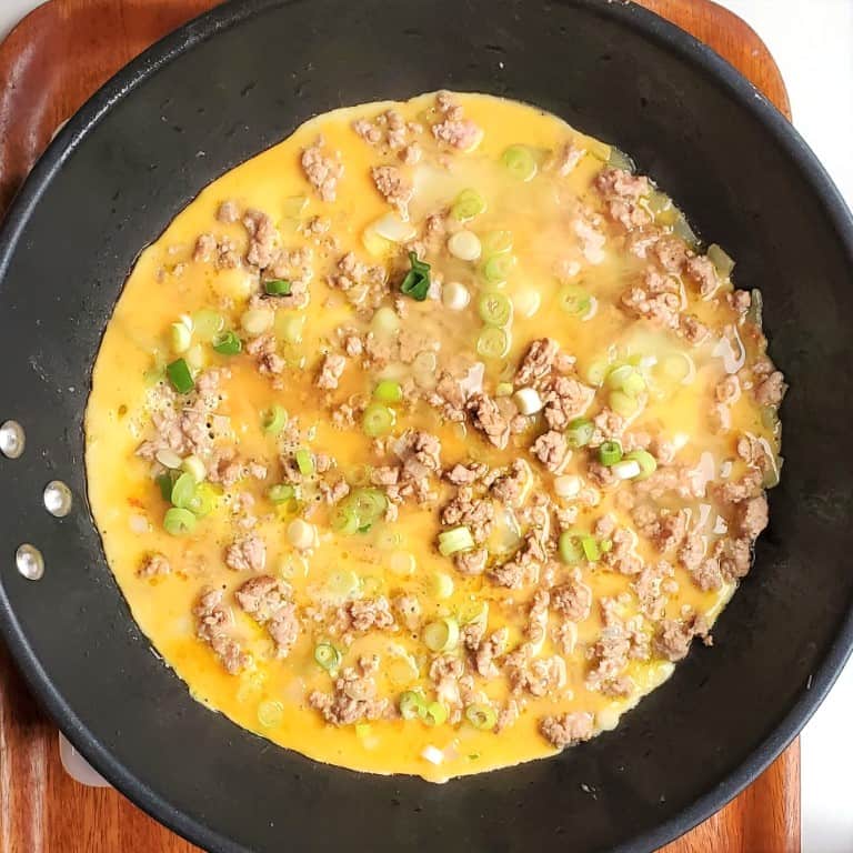 Cooking eggs in pan for the vietnamese omelet pregnancy recipe